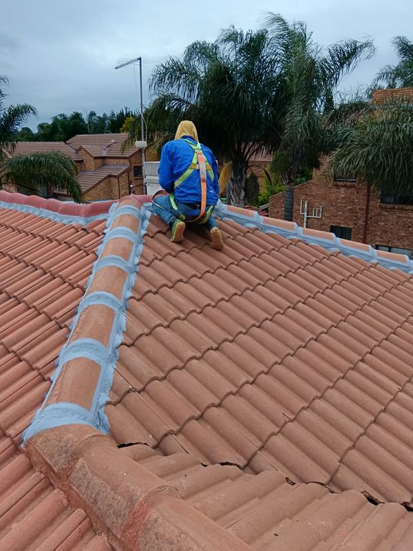 Ridge caps being bedded and pointed on a tiled roof