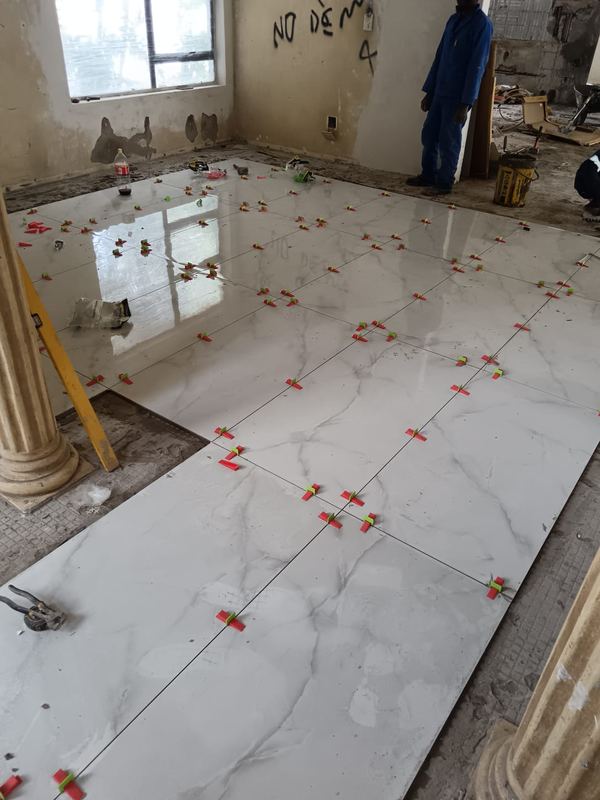 Large-format marble tiles being laid to levelling clips