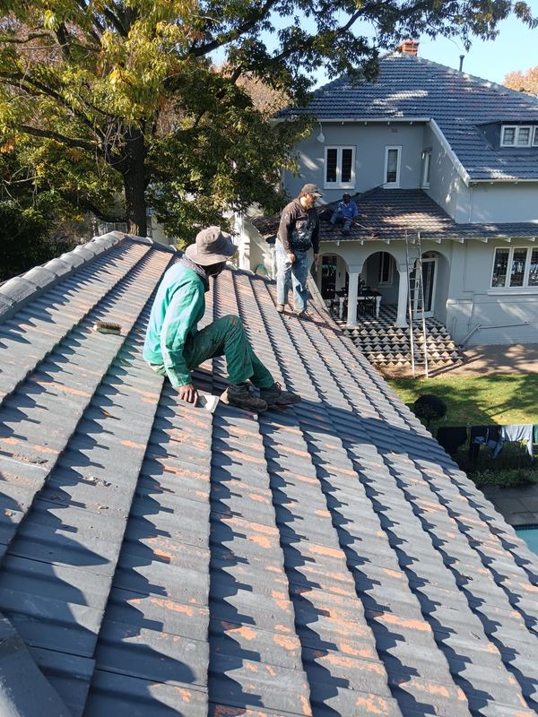 Concrete roof tiles being laid to battens over underlay