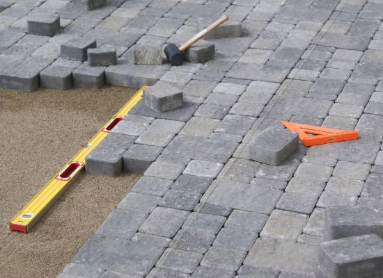 Cobble pavers being laid to level on a bedding layer