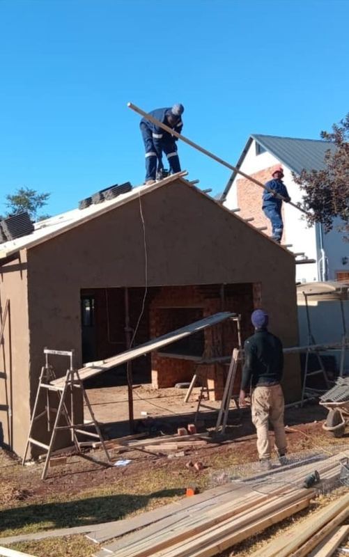 Ridge board and rafters being levelled on a new gable
