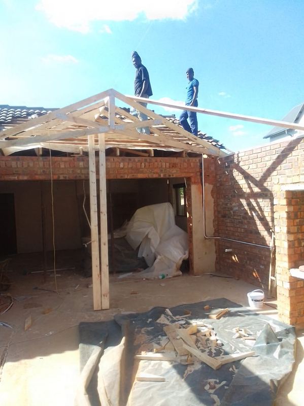 Timber gable frame raised over a covered brick patio